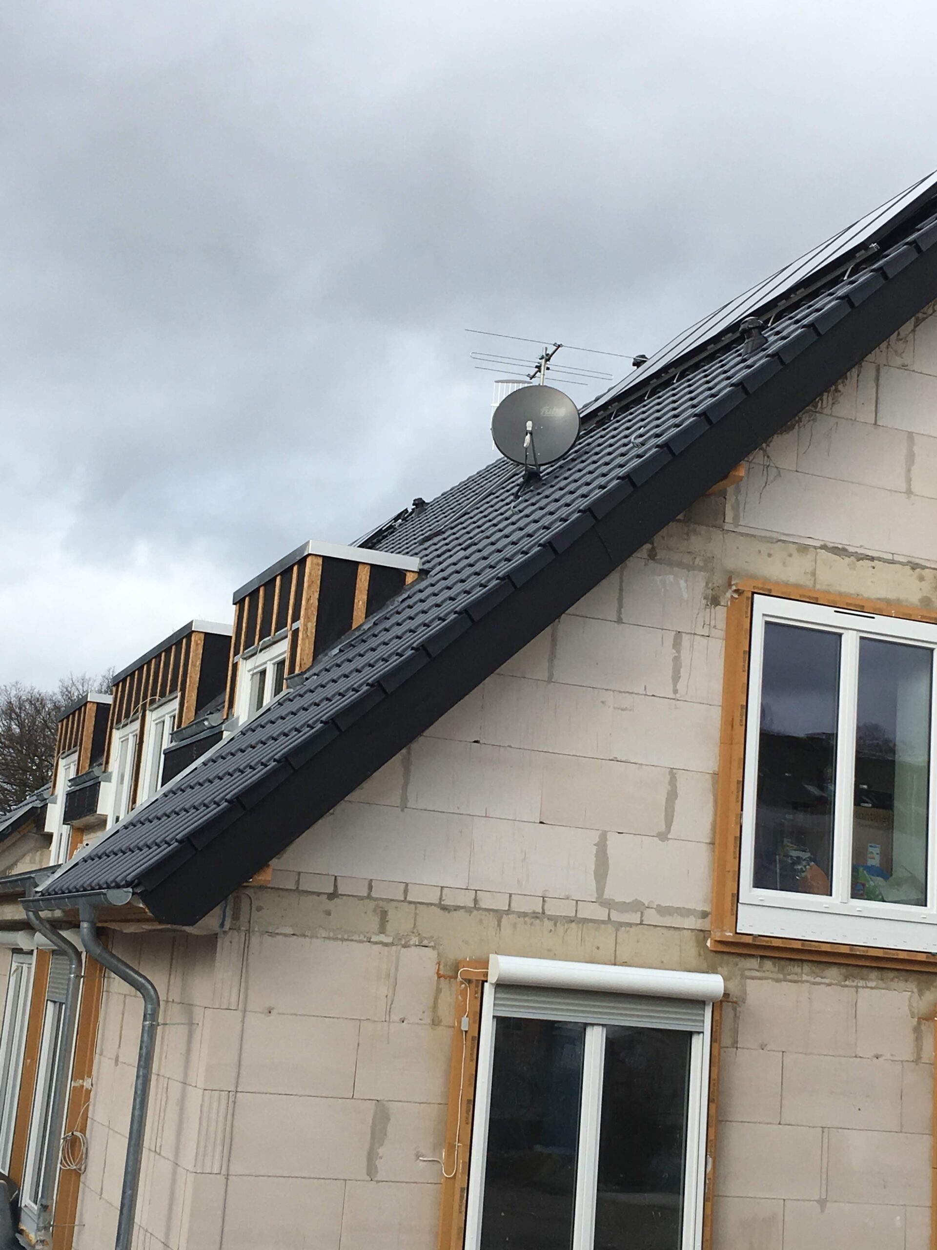 Rohbau eines Mehrfamilienhauses in Langenfeld Rheinland mit montierter Satellitenschüssel auf dem Dach
